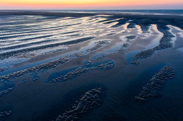 Patterns on the beach of Ameland at low tide in the blue hour