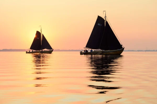 Botters on open water at sunset.