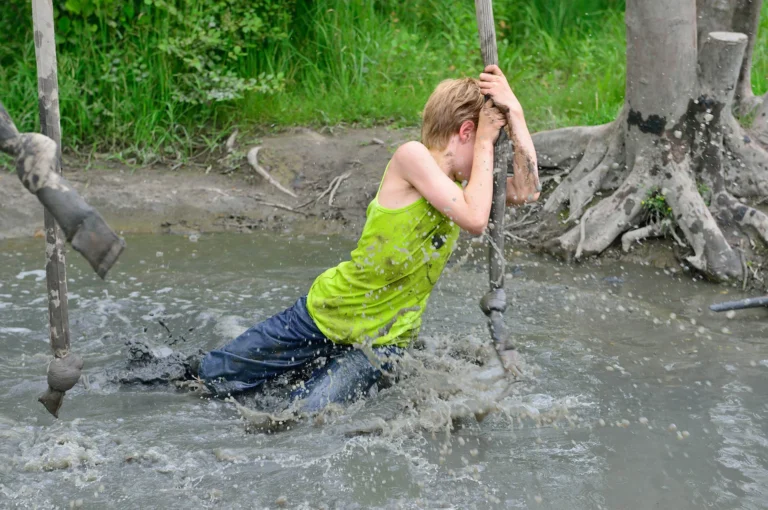 Jongen aan touw in modder.