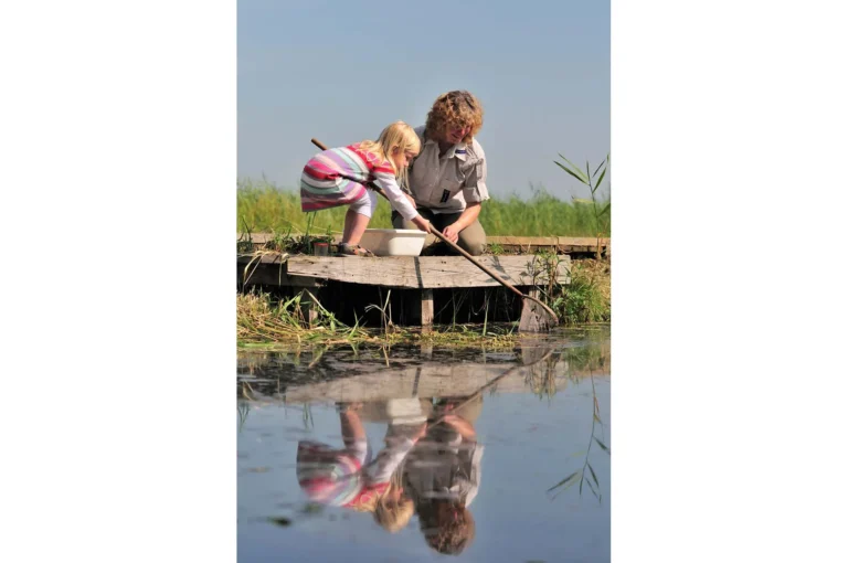 Kind met schepnetje en boswachter