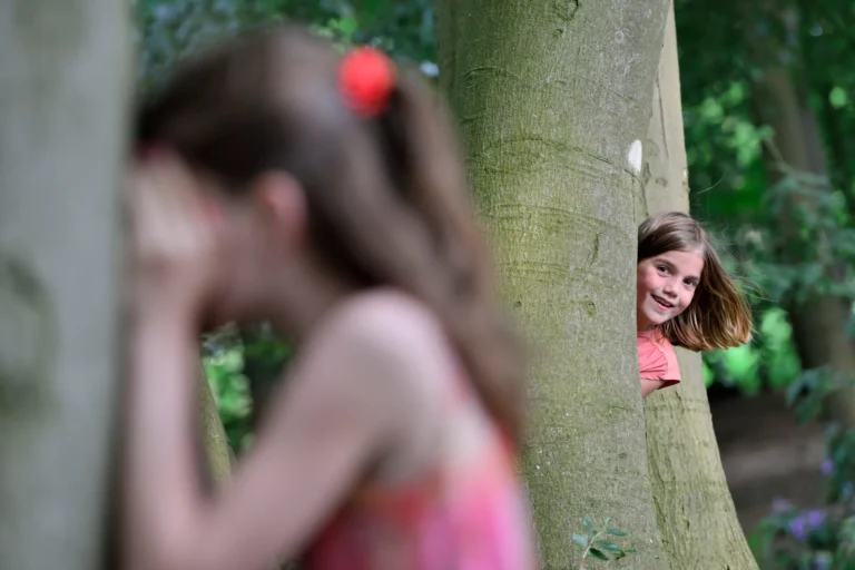 Kinderen spelen verstoppertje in bos