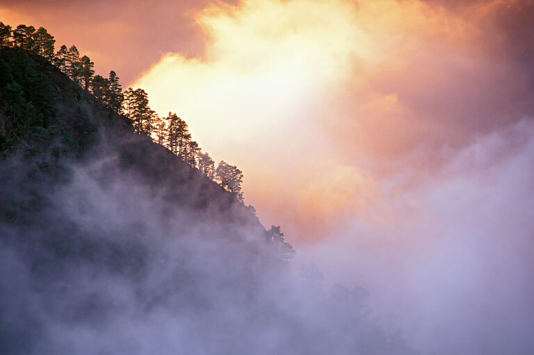 Berglandschap met door zon beschenen wolken.