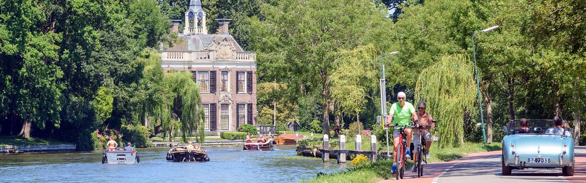 River Vecht with country estate Rupelmonde, boats, cyclists and vintage car.