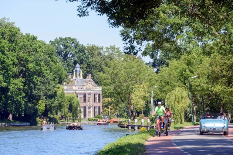 River Vecht with country estate Rupelmonde, boats, cyclists and vintage car.